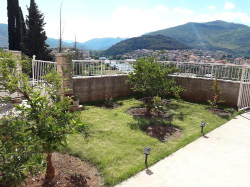 a garden with two trees in the grass at Apartment Nijona in Trebinje