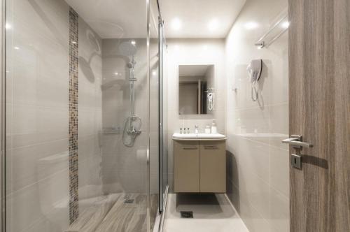 ein Bad mit einer Dusche und einem Waschbecken in der Unterkunft Vice Hotel in Laganas