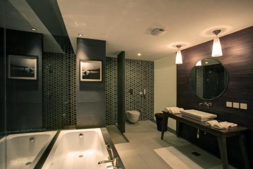 a bathroom with a tub and a toilet and a sink at Luxury Goa Villa in Candolim