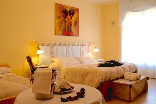 a hotel room with two beds and two tables at B&B Eremes in Cuneo