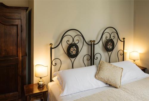 a bed with a white pillow and two lamps at La Locanda Del Capitano in Montone