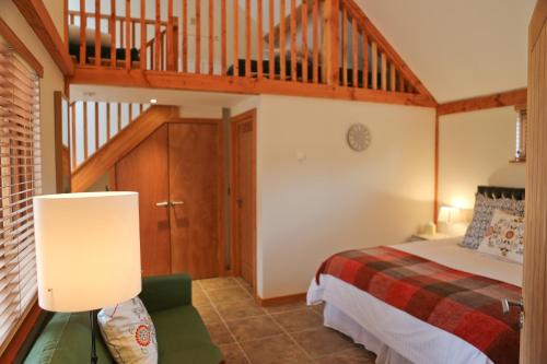 a bedroom with a bed and a wooden staircase at The Grove Cromer in Cromer