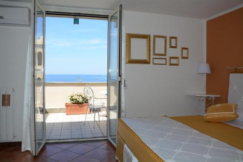a bedroom with a sliding glass door with a view of the ocean at Maison Huguette in Civitavecchia