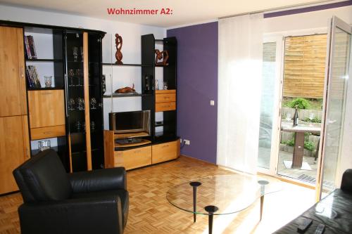 a living room with a black chair and a glass table at Ferienwohnungen 99a in Weimar
