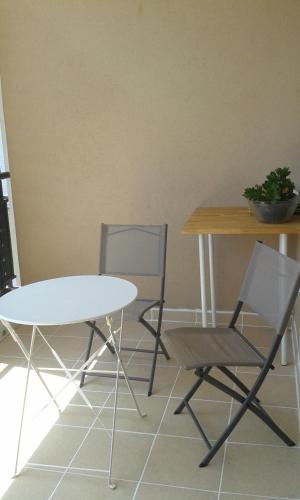 two chairs and a table and a table and chair at Via Calanca in Marseille