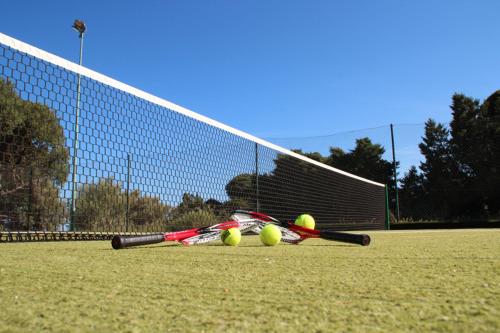 a group of tennis rackets and balls on a court at I Ginepri Hotel in Cala Gonone
