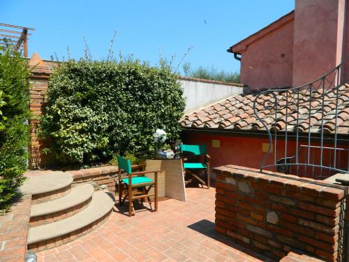 a patio with chairs and a table and stairs at Villa il Pino by VacaVilla in Lari