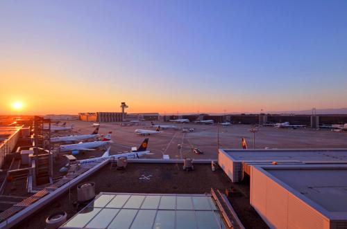 a view of an airport with airplanes parked at sunset at MY CLOUD Transit Hotel - Guests with international flight only! in Frankfurt