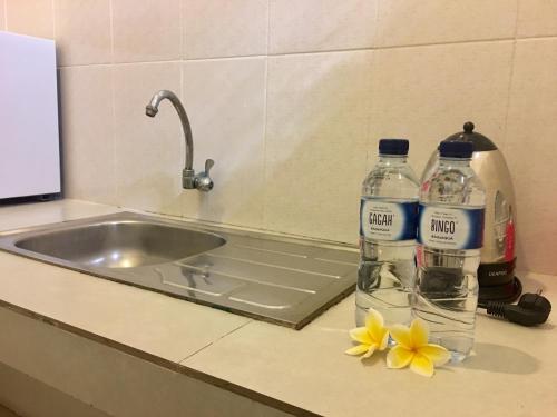 two bottles of water on a counter next to a sink at The Celuk Homestay in Jimbaran