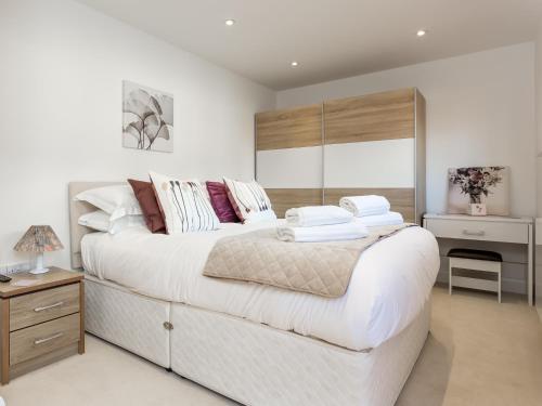 1 dormitorio con 1 cama blanca grande y escritorio en Dennetts House, en Poole