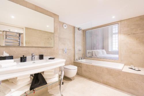 a bathroom with a sink and a tub and a toilet at Palais Saleya Boutique Hôtel in Nice