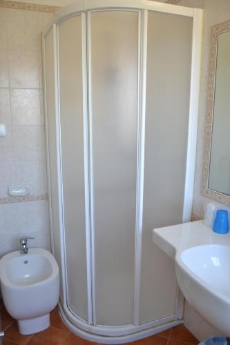 a bathroom with a shower and a toilet and a sink at Hotel Apis in Rimini