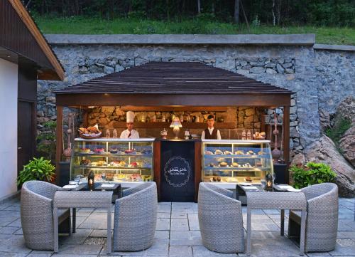 een bakkerij met twee tafels en stoelen voor een winkel bij RK Sarovar Portico in Srinagar