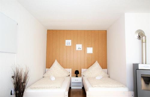 2 camas en una habitación pequeña con pared en Work & Stay in Zuelpich, en Zülpich