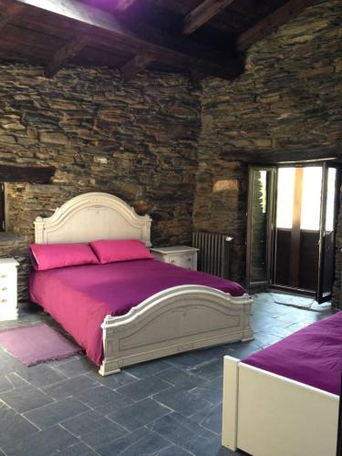 a bedroom with a large bed in a stone wall at El Balcón de Sotillo - Las Médulas - Senderismo por Canales Romanos in Sotillo de Cabrera