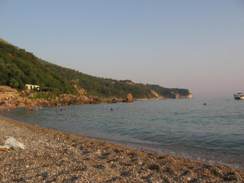 a beach with people swimming in the water at Reževići Apartments in Petrovac na Moru