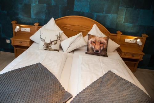 two pictures of a dog on a bed at Hostellerie Les Bagenelles in Sainte-Marie-aux-Mines