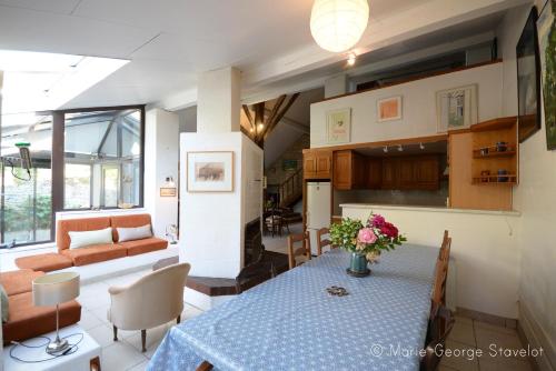 une cuisine et un salon avec une table et un canapé dans l'établissement La Victoire de Noyers, à Noyers-sur-Serein