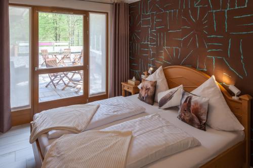 a bedroom with a bed with a dog sitting on it at Hostellerie Les Bagenelles in Sainte-Marie-aux-Mines