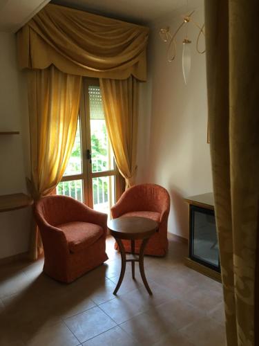 a living room with two chairs and a table and a window at Infinity in Cervia
