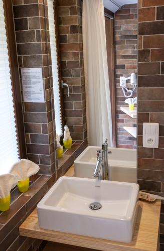 a bathroom with a sink and a bath tub at Hostellerie Les Bagenelles in Sainte-Marie-aux-Mines