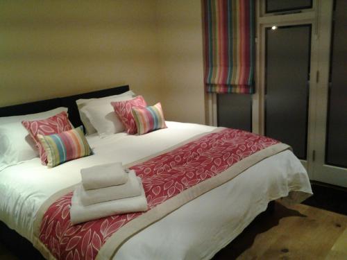 a large bed with red and white sheets and pillows at The Green Dragon in Market Lavington
