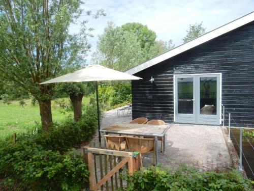 una mesa de picnic con una sombrilla frente a un edificio en Vecht & Weide Weesp, en Weesp