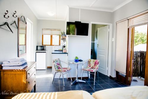 Cobie Apartment في ستيلينبوش: مطبخ مع طاولة وكراسي في غرفة