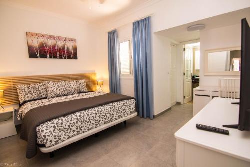 プエルト・デル・カルメンにあるVilla Sontrobatのベッドルーム1室(青いカーテン付きのベッド1台付)