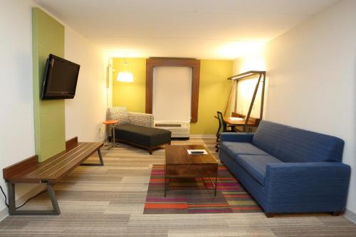 a living room with a blue couch and a table at Holiday Inn Express & Suites Newport News by IHG in Newport News