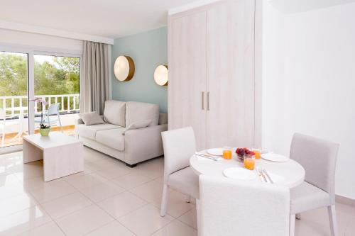 a white living room with a table and chairs at HSM Solivera in Paguera