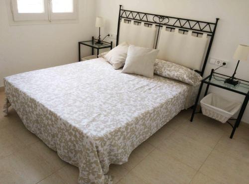 マルグラット・デ・マルにあるApartamento Felicidadのベッドルーム1室(大型ベッド1台、ナイトスタンド2台付)