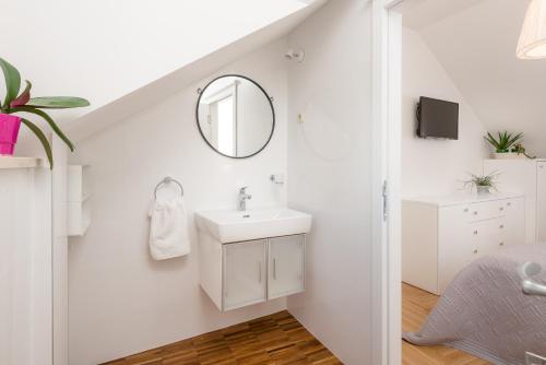 een witte badkamer met een wastafel en een spiegel bij Villa Lipa Dora in Murvica