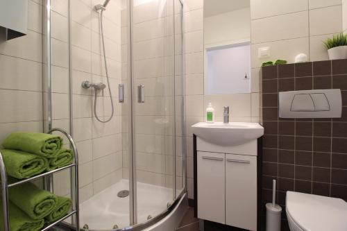 łazienka z prysznicem, umywalką i toaletą w obiekcie Długa Apartments Old Town w Gdańsku