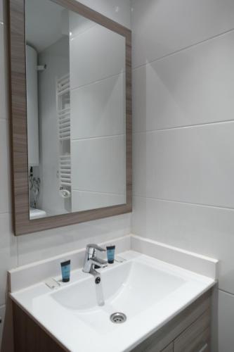 ein Badezimmer mit einem weißen Waschbecken und einem Spiegel in der Unterkunft P&C Dolsa in Pas de la Casa