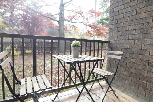 a table with two chairs and a potted plant on a balcony at Leski Club in Jindabyne