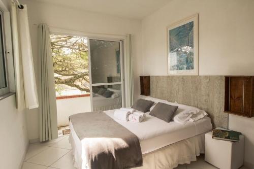 a bedroom with a bed and a large window at Pousada Green in Florianópolis
