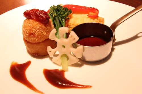 a plate of food with meat and vegetables and sauce at Aura Tachibana in Hakone