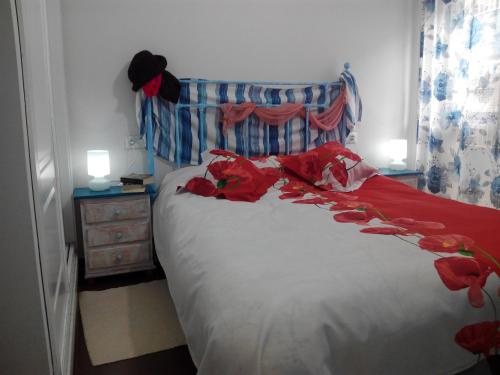 Duplex la Pecera في مورش: غرفة نوم مع سرير مع زهور حمراء عليه