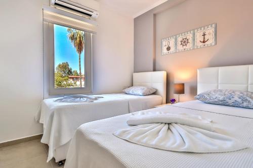 Duas camas num quarto com uma janela em Kasinn Apart Hotel em Kas