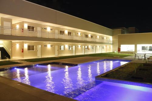 a building with a large swimming pool at night at Hotel Imperador in Gurupi