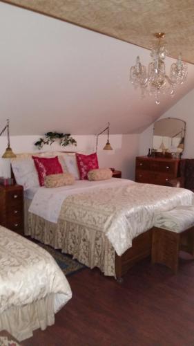 a bedroom with two beds and a chandelier at Gite Agricole Les Lilas in Saint Wenceslas