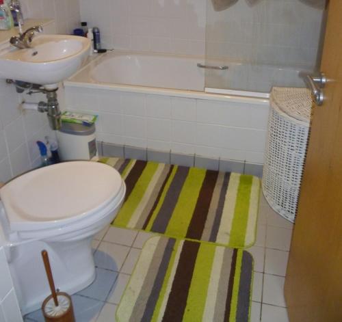 a bathroom with a tub and a toilet and a sink at Luxury Town Centre Apartment in Kinsale