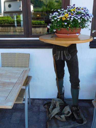 a table with a pot of flowers on top of it at Hotel Kirchenwirt in Kirchberg in Tirol