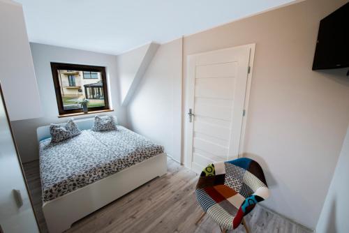 a small bedroom with a bed and a mirror at Villa Agawa in Niechorze