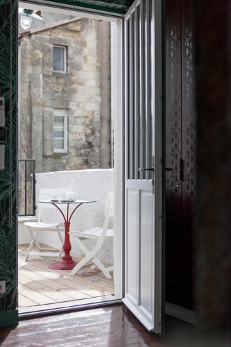 an open door to a patio with a table at Une Chambre Chez Dupont in Bordeaux
