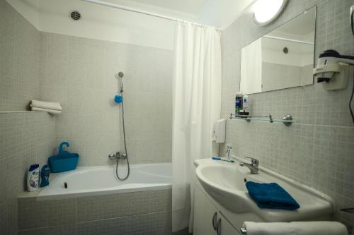 y baño con bañera, lavamanos y ducha. en Salt Hill Apartmanok en Egerszalók