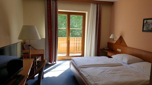 a hotel room with a bed and a window at Hotel Geier in Bad Schönau