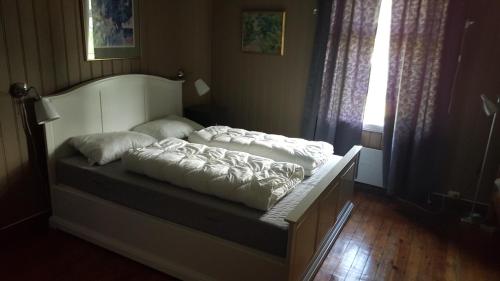 a bed with pillows on it in a room at Eidsfoss slusevokterbolig in Lunde