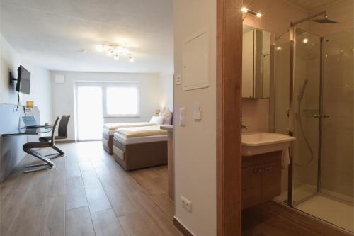 y baño con cama, ducha y lavabo. en Aparthotel Donaustern, en Asbach-Bäumenheim